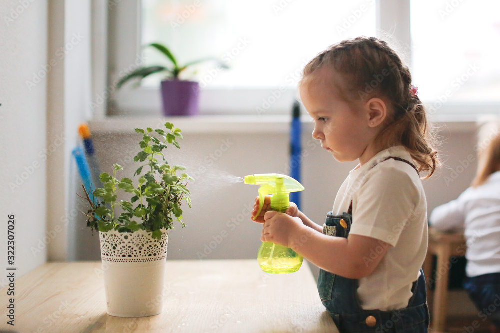 A toddler watering a house plant, Moorside Pre-School - Nursery Education Lancaster